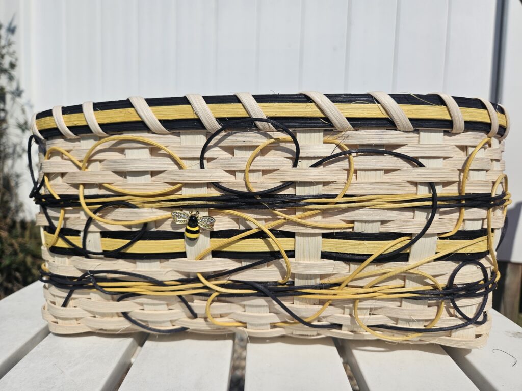 Black,yellos and Natural reed woven to create a simulation on the flight of a bumble bee